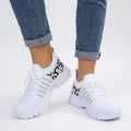 Hvide sneakers med snørebånd, kraftig sål og sort grafisk hælmønster